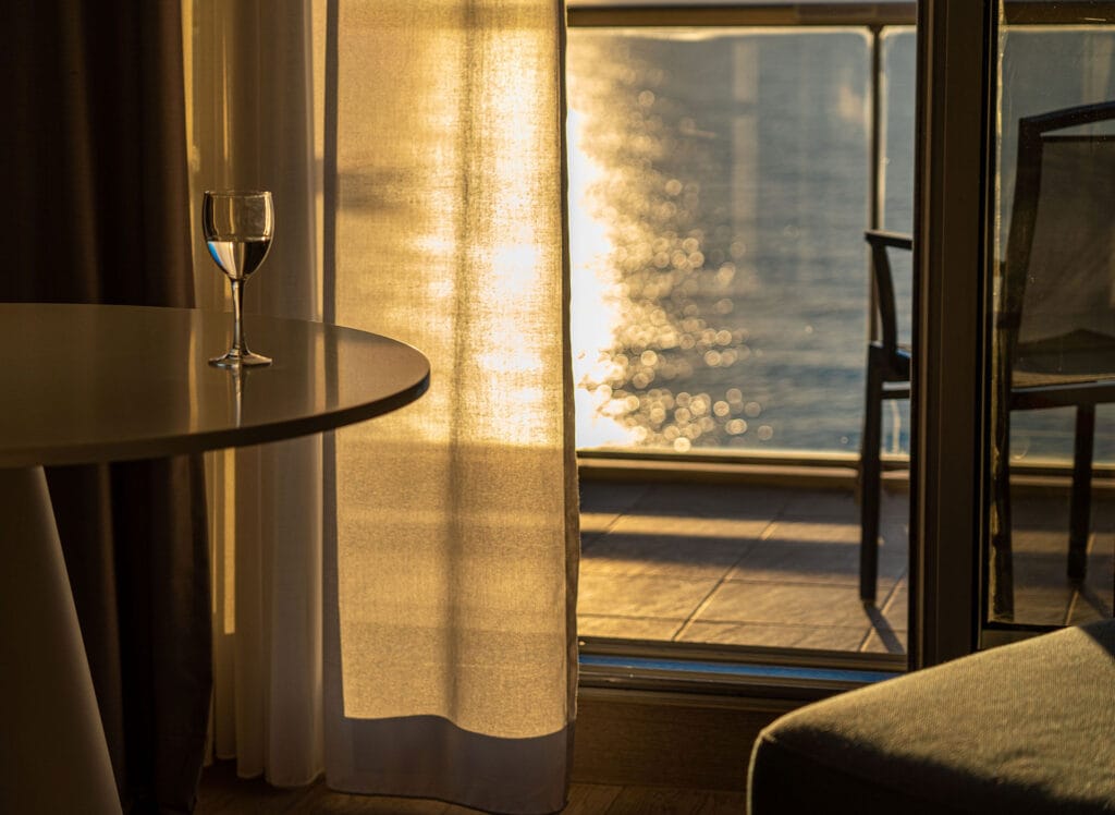 Warm oceanfront Airbnb interior at sunset, showing how atmosphere and guest experience create perceived value before guests book.
