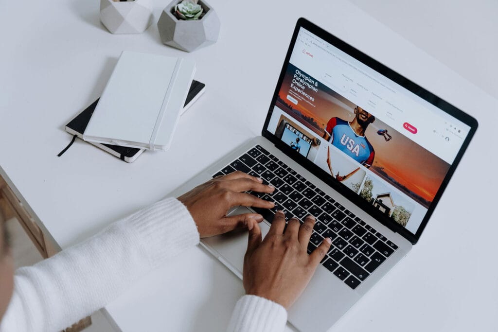Guest comparing Airbnb listings on a laptop while browsing vacation rental search results