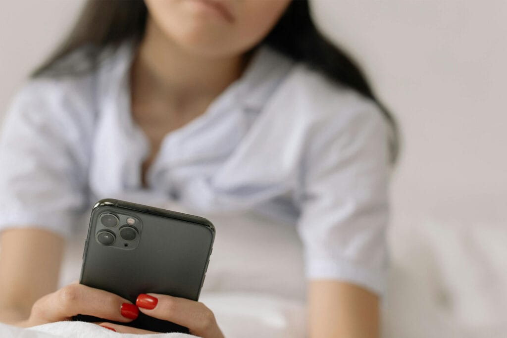 Person scrolling on phone comparing Airbnb listings before booking decision